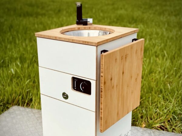 En kompakt campingvask med en vask i rustfrit stål og et trælåg.